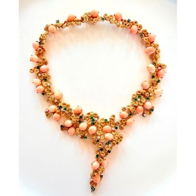 un gros plan d'un collier composé de perles roses sur un fond blanc
