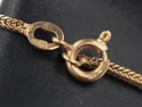 a close up of a gold chain with a clasp on it