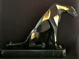 statue of a black cat with gold accents sitting on a black base
