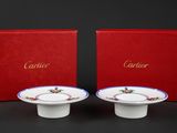 pair of red and white plates with gold trim and a red box