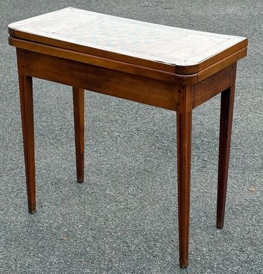 une petite table en bois avec un plateau en marbre, posée à même le sol