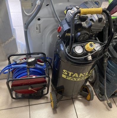 un petit compresseur d'air posé à côté d'une pile d'autres équipements