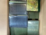 many books in a cardboard box on the floor