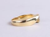 a close up of a gold ring on a white surface
