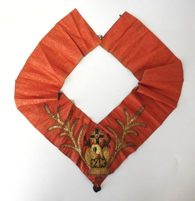 une image représentant un collier rouge et doré orné d'un cerf