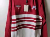 a red and white sweater hanging on a hanger on a wall