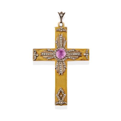 a gold cross with a pink stone surrounded by diamonds