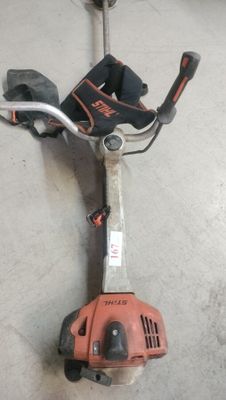 an image of a corded string trimmer in a garage