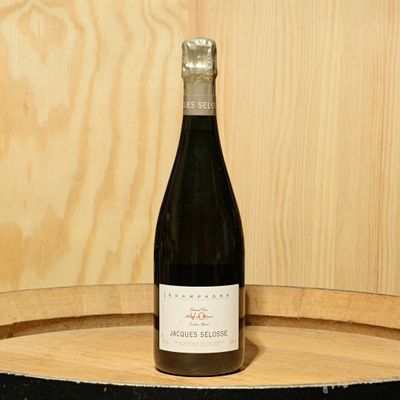 a bottle of wine sitting on top of a barrel