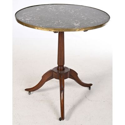 une table ronde avec un plateau en marbre et des pieds en bois