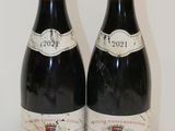 deux bouteilles de vin posées sur une table l'une à côté de l'autre