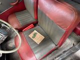 a red and black car with a brown seat and steering wheel