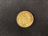 a gold coin on a black surface