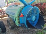 a blue fan sitting on the ground next to a blue tractor