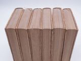 six books stacked on top of each other on a white surface