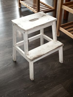 un tabouret en bois blanc posé sur un parquet en bois massif