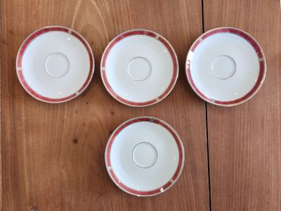four cups and saucers sitting on a wooden table