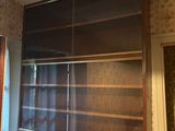 a picture of a room with a bookcase and a radiator in it