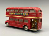 a red double decker bus with a man standing in the door