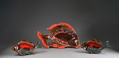 trois figurines de poissons en céramique posées sur une surface blanche
