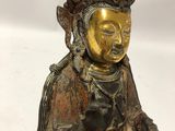 a person holding a statue of a person sitting on top of a table