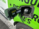 a green and white van with a gas pump attached to it ' s side