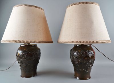 une paire de lampes de table en céramique marron avec des abat-jours beiges sur fond gris