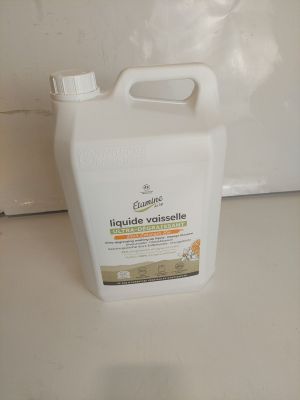 une bouteille de liquide posée sur un plan de travail à côté d'un micro-ondes