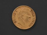 a close up of a gold coin on a black surface