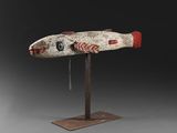 a wooden sculpture of a fish on a metal stand
