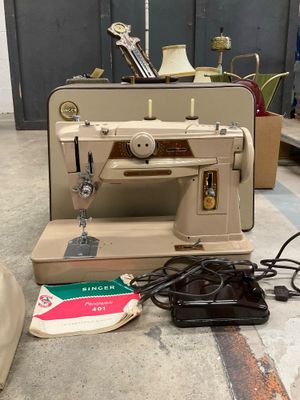 a sewing machine sitting on the floor next to a bag