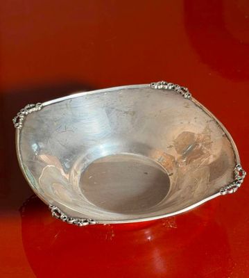 a silver bowl sitting on a red surface