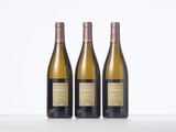 three bottles of wine sitting on top of a white table
