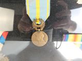 un ours en peluche tenant une médaille et un ruban