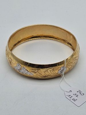 an image of a gold bangle with a tag on it