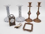 four candles, a clock, a picture frame, and a picture frame on a table