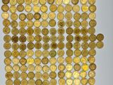 a white plate topped with lots of gold coins on top of a table