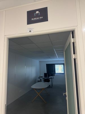 une pièce avec une table et une chaise à l'intérieur, et une pancarte sur la porte