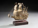 maquette en bois sculpté représentant un voilier, posée sur un socle en bois