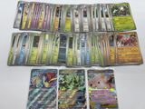 Plusieurs cartes Pokémon sont posées sur une table blanche.