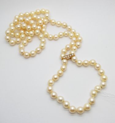 gros plan d'un collier de perles sur une surface blanche