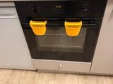two yellow cups on top of a stove in a kitchen