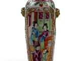 a vase with a painting on it sitting on a table