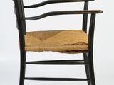 a black wooden chair with a wicker seat on a white background