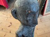 a hand holding a statue of a monkey on a wooden floor