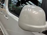 a side view mirror of a white car in a showroom