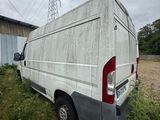 a van that is sitting in the grass near a building