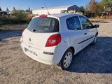 une petite voiture blanche garée sur la terre battue
