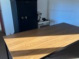 une table en bois dans une pièce, avec une armoire en arrière-plan
