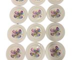 six white plates with flowers painted on them on a white surface